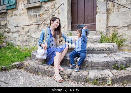 Madre e piccolo bel bambino ragazzo seduto su scale di pietra antica Foto Stock