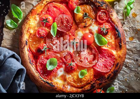 Pizza Margherita fresca e gustosa a base di pomodori, mozzarella e basilico. Pizza Margherita con mozzarella e pomodori. Foto Stock