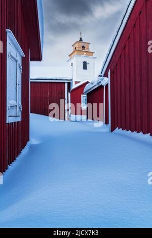 Nuvole sopra le case rosse coperte di neve e il campanile, Gammelstad Church Town, Patrimonio dell'Umanità dell'UNESCO, Lulea, Svezia, Scandinavia, Europa Foto Stock