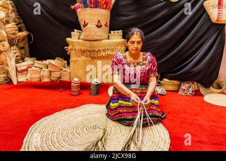 Gli artigiani K'iche mostrano i loro bei cappelli di paglia intessuti, Guatemala, America Centrale Foto Stock