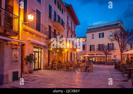 Al fresco mangiare in piazza locale nel centro storico di Alcudia al tramonto, Alcudia, Maiorca, Isole Baleari, Spagna, Mediterraneo, Europa Foto Stock