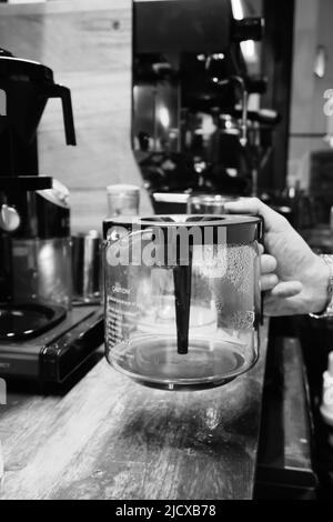 Svuotare la caffettiera del filtro nella vista ravvicinata del barista Foto Stock