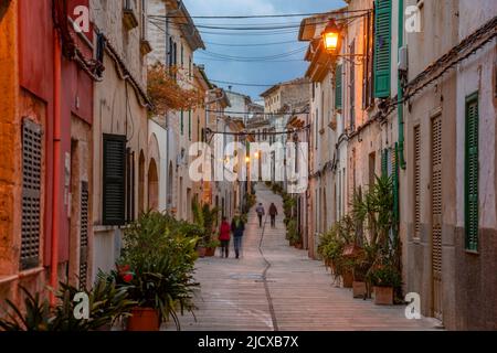 Persone in strada in strada stretta al tramonto nel centro storico di Alcudia, Alcudia, Maiorca, Isole Baleari, Spagna, Mediterraneo, Europa Foto Stock