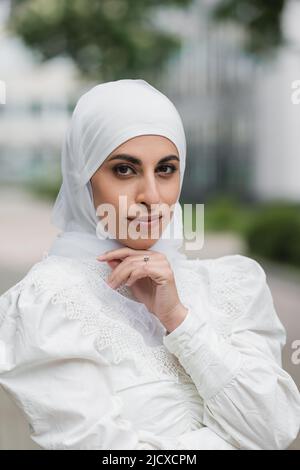 ritratto di sposa musulmana in hijab con anello di diamante sul dito guardando la macchina fotografica Foto Stock