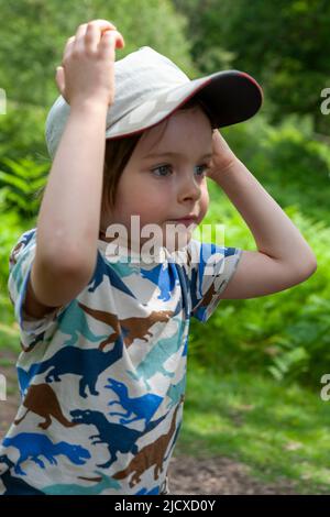 Ragazzino, 5 anni, che si concentra sul suo gioco privato a Leonardslee Gardens, West Sussex, Regno Unito. MODELLO RILASCIATO Foto Stock