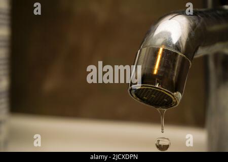 Mancanza d'acqua goccia d'acqua sul rubinetto vista ravvicinata Foto Stock