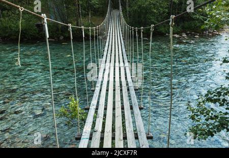 Corda di rickety ponte sul fiume che scorre veloce Foto Stock