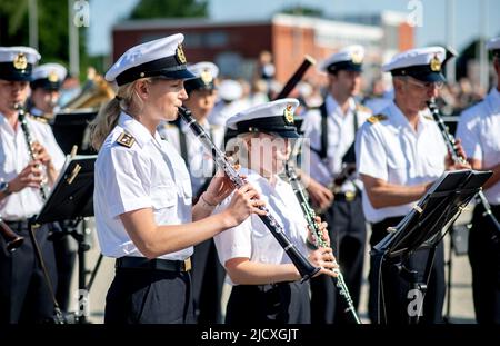 Wilhelmshaven, Germania. 16th giugno 2022. I membri del corpo di musica navale Wilhelmshaven suonano i loro strumenti durante l'arrivo della fregata 'Lübeck' nel porto presso la base navale. Dopo 32 anni di servizio, la nave è tornata da un dispiegamento per l'ultima volta. L'equipaggio della nave da guerra si è diretto verso il porto di Wilhelmshaven dopo cinque mesi di dispiegamento nel Mediterraneo. Credit: Hauke-Christian Dittrich/dpa/Alamy Live News Foto Stock