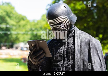 Erlangen, Germania. 16th giugno 2022. Cospayer Frank, qui in costume come personaggio di Star Wars Kylo Ren, guarda il suo smartphone mentre visita il Salone Comic 2022 di Erlangen. Credit: Nicolas Armer/dpa/Alamy Live News Foto Stock