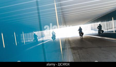 Erlangen, Germania. 16th giugno 2022. Un ciclista passa attraverso un sottopasso riflesso nelle pareti di vetro. Credit: Nicolas Armer/dpa/Alamy Live News Foto Stock