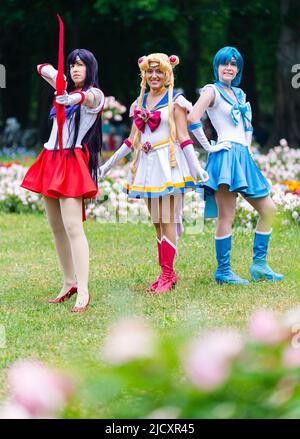 Erlangen, Germania. 16th giugno 2022. I cosplayers Juchan Cosplay (l-r), Luminia e Abysinier si levano in piedi nei loro abiti cosplay come Sailor Mars (l-r), Sailor Moon e Sailor Mercury durante una visita al Salone Comic 2022 a Erlangen nel giardino botanico cortile. Credit: Nicolas Armer/dpa/Alamy Live News Foto Stock