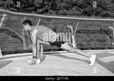 Sportivo tenere affondo posizione facendo stretching routine dopo outdoor atletica allenamento, stretching Foto Stock