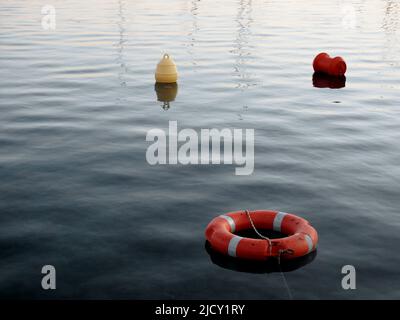 Lifebuoy e marcatrice galleggianti sul mare Foto Stock