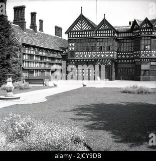 1940s, Historical, Bramall Hall, Bramhall, Stockport, Inghilterra, Regno Unito. Una casa padronale Tudor a graticcio che risale al 14th secolo, con aggiunte successive, la casa e il parco circostante è stato acquistato dall'autorità locale nel 1935 e divenne un museo. La famiglia Davenport, che si ritiene abbia costruito la casa, ha tenuto il maniero per oltre 500 anni. Qui si vede una vista dal 1940s da ovest, dell'ingresso principale, cortile, ala sud e la Grande Sala nel centro. Foto Stock