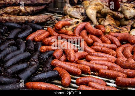 Grande grill con salsicce e budino nero cotto sulle costolature. Cucina tipica argentina. Cibo a base di carne animale. Foto Stock