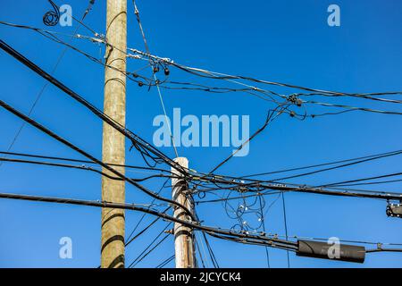 Immagine dettagliata di un gruppo di fili e cavi su poli di uttilità Foto Stock