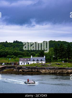 Traghetto Ulva, Isola di Mull, Scozia – Vista attraverso l'Isola di Ulva, con un traghetto passeggeri che attraversa il ristorante Boathouse Inn sull'isola di Ulva Foto Stock