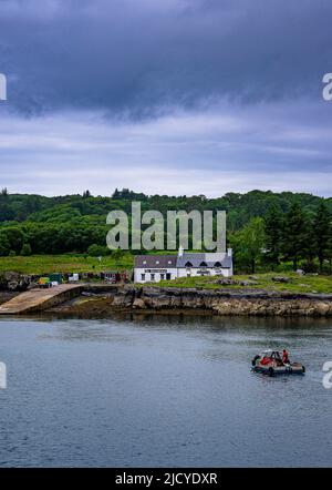 Traghetto Ulva, Isola di Mull, Scozia – Vista attraverso l'Isola di Ulva, con un traghetto passeggeri che attraversa il ristorante Boathouse Inn sull'isola di Ulva Foto Stock