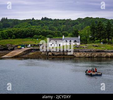 Traghetto Ulva, Isola di Mull, Scozia – Vista attraverso l'Isola di Ulva, con un traghetto passeggeri che attraversa il ristorante Boathouse Inn sull'isola di Ulva Foto Stock