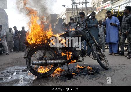 I membri di Anjuman-e-Tahafuz Dukandar stanno bruciando la motocicletta mentre stanno tenendo la dimostrazione di protesta contro l'aumento di prezzo dei prodotti petroliferi, fuori Qadam GHA Mola Ali (A.S) a Hyderabad giovedì 16 giugno 2022. Foto Stock