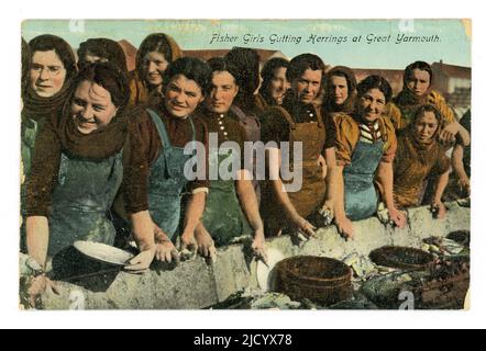 Fotografia originale dei primi anni del 1900, circa 1919, colorata/colorata e ancora stampata negli anni '30 - una cartolina di ragazze allegre fisher che guting herrings a Great Yarmouth, questi erano probabilmente lavoratori migranti stagionali scozzesi. Le grondaie lavoravano a lungo conca chiamati farlins o farlans e dovevano ordinare l'aringa per dimensione e qualità. La cartolina è stata pubblicata nel giugno 1931, Great Yarmouth, Norfolk, England, U.K. Foto Stock