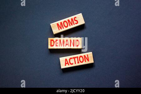 Simbolo di azione richiesta moms. Parole di concetto le mamme richiedono l'azione su blocchi di legno su uno sfondo nero bello tabella. Business, finacial e Moms Foto Stock