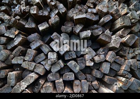 Pile più grandi di traversine ferroviarie in legno usate impilate. Le traversine di legno sono migliori di altre traversine ferroviarie ad assorbire la pressione. Foto Stock