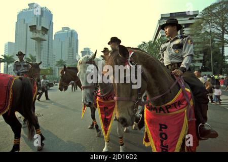 La squadra di polizia indonesiana è in servizio su Thamrin Street durante il Carnevale di Giacarta 2004 nel centro di Jakarta, Jakarta, Indonesia. Foto Stock