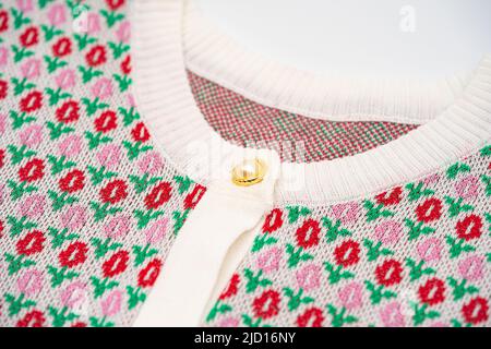 Da vicino ai bottoni giramonzoli rosa e rosso del maglione in oro perla sulla parte superiore del maglione tshirt. Foto Stock