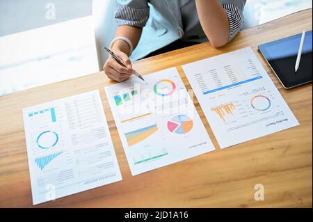 Donna d'affari asiatica professionista o dirigente femminile che legge un documento di affari, che rivede i dati finanziari sul rapporto nella riunione. Top v Foto Stock