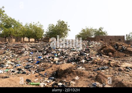 Rifiuti di plastica sparsi e altri rifiuti in un ambiente urbano africano; concetto di mancanza di gestione dei rifiuti solidi Foto Stock