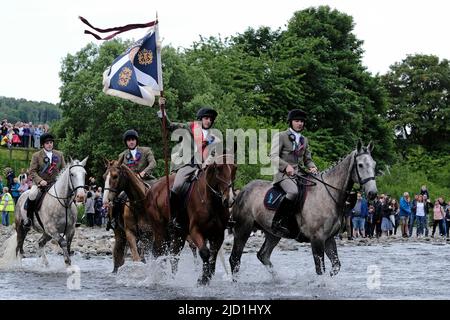 Selkirk, Regno Unito. 17 giugno 2022. Selkirk Riding comune 2022. Venerdì. Adam Nichol, Selkirk Royal Burgh Standard Bearer, 2022, affiancato dai suoi partecipanti, Thomas Bell, Conall Fairbairn, Fraser Easson, Thomas Stanners, guada il fiume Ettrick al primo incrocio, dirigendosi verso 'Saf out', seguito da una cavalcata di cavalli di oltre 260 piloti. Selkirk commemora e celebra la sua storia durante l'annuale Common Riding, che si tiene il secondo venerdì dopo il primo lunedì di giugno, quando i confini del townÕs o ÔmarchesÕ sono cavalcati. Di solito nella regione del 300-400, Selkirk vanta una delle più grandi cavalcate di cavalli Foto Stock