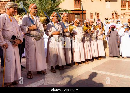 Gli uomini che suonano canzoni tradizionali durante il mercato della capra del Venerdì a Nizwa, Sultanat of Oman Foto Stock