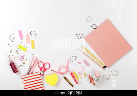 Girly set in rosa pastello tonalità cancelleria su sfondo bianco, piatta, mock up. Cornice di cancelleria colorata. Concetto di ritorno a scuola. Foto Stock