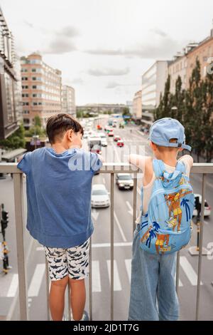 Bambini in piedi sul viadotto e guardando il traffico Foto Stock