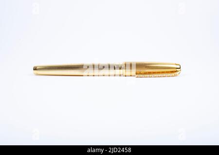 Golden pen isolati su sfondo bianco Foto Stock