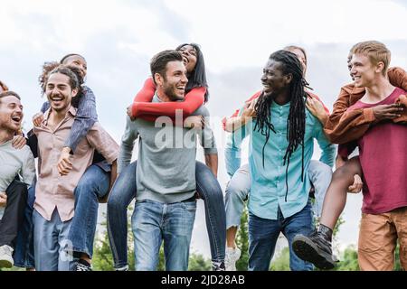 Felice gruppo multirazziale di amici divertirsi all'aperto - Vacanze estive e stile di vita di amicizia - Focus sul volto africano uomo Foto Stock