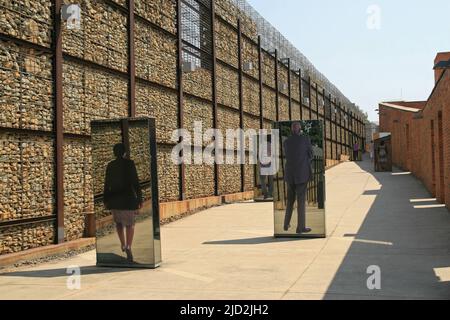 Mostra specchi all'interno della parete del museo esterno dell'Apartheid, Johannesburg, Gauteng, Sudafrica. Foto Stock