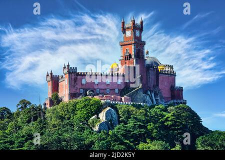 Il colorato palazzo di Sintra si trova sulla cima di una collina con cielo blu e nuvole. Foto Stock
