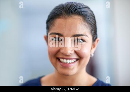 Positivo e professionale. Primo piano ritratto di una giovane donna d'affari attraente nel suo ufficio. Foto Stock