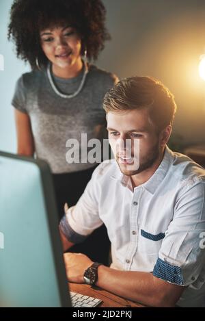 Mettendo nelle ore per realizzare il successo. Shot di colleghi che lavorano tardi in ufficio. Foto Stock