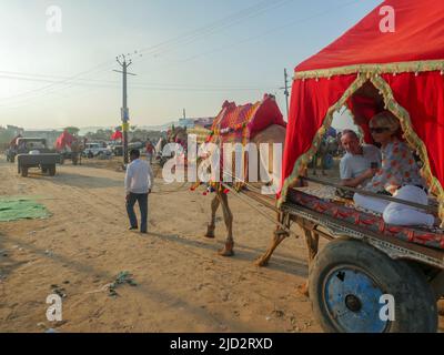 Pushkar, Rajasthan India - 04 novembre 2019 : i turisti stranieri amano guidare su carrello del cammello alla fiera del cammello di pushkar in India. Foto Stock