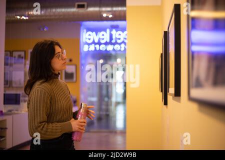 Rachel McDermott guardando la fotografia nella galleria PhotoWorks di Street Level, nell'area Trongate del centro città, a Glasgow, Scozia, 10 aprile 2022. Foto Stock