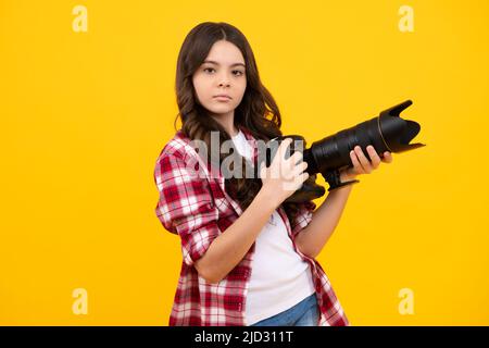 Hobby o carriera per i principianti del fotografo. Ragazza adolescente con macchina fotografica moderna che fa video e foto. I bambini usano la macchina fotografica digitale, fotografando. Foto Stock