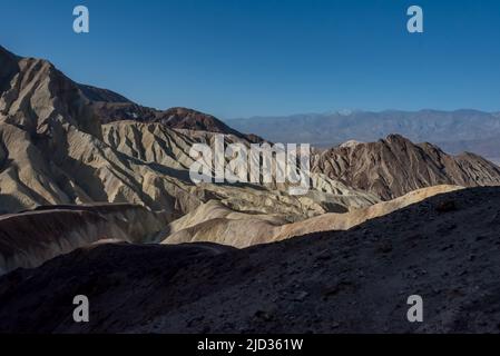 Vista dal percorso escursionistico della Red Cathedral che si affaccia a ovest sul Golden Canyon e la Death Valley, verso le montagne Panamint che ancora mostrano neve leggera. Foto Stock