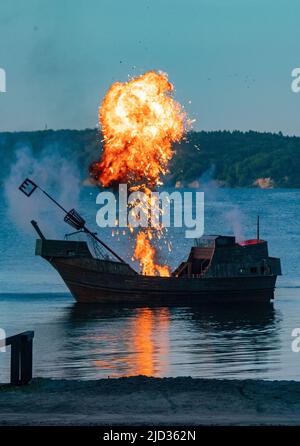 16 giugno 2022, Meclemburgo-Pomerania occidentale, Ralswiek: Dopo un'esplosione su una cog medievale, una nube di funghi di fuoco sorge durante una prova del Festival Störtebeker di fronte al Naturbühne Ralswiek su Rügen. Per molto tempo era tranquilla di fronte al panorama del Mar Baltico della scena naturale Ralswiek su Rügen. Ora ritorna il Störtebeker Festival. Si tratta di amore, ma anche macchinazioni scure gettano le loro ombre. Il gioco "in the Face of the Wolf" con i leggendari pirati Klaus Störtebeker e Goedeke Michels ha la sua prima sull'isola di Rügen su 18. 06,2022. Foto: Stefan Sauer Foto Stock