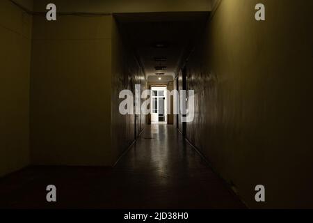 Un vecchio corridoio scuro è lungo in un edificio di uffici nel centro della città in Ucraina, una porta al corridoio, un'uscita, un edificio Foto Stock