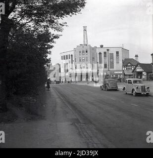 1940, storico, vista a distanza del cinema Tudor a Bramhall, Stockport, Inghilterra, Regno Unito. Situato in un angolo con Woodford Road e Meadway, l'edificio è stato progettato dall'architetto George Clayton, con l'auditorium decorato in stile Tudor e aperto il 31st marzo 1935 con Clark Gable in "IT Happen One Night". Questa foto, scattata nel 1940, ha visto il film 'Dad Rudd MP' essere mostrato. Le auto dell'epoca possono essere viste parcheggiate sulla strada. Foto Stock