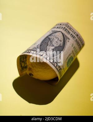 Una banconota da un dollaro e' avvolta su Lemon Foto Stock