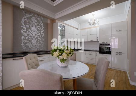Lussuoso appartamento monolocale con moderna cucina bianca e pareti di rose Foto Stock